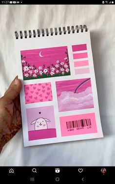 someone holding up a notebook with pink and purple designs on it, which are part of a page