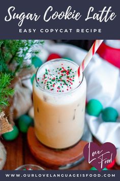 a drink with a candy cane in it sitting on a table next to christmas decorations