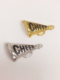 Cheer Megaphone Hanging Charm - Silver Plated Cheer Megaphone Hanging Charm - Gold Plated Plating:18kt Plated Size: 13mm x 25mm Price per charm Product Care: -Apply beauty products such as perfume, hairspray or deodorant before wearing your jewelry as certain chemicals in these products may damage the finish. Always remove your jewelry before swimming, bathing, doing household chores or using abrasive cleaners. - Fast Shipping - orders ship in 1-2 business days - Satisfaction Guarantee, Returns Cheerleading Megaphones, Cheer Megaphone, Real Gold Chains, Cheer Coach, Softball Gifts, Engraved Cuff, Cheerleading Gifts, Pom Pom Girl, Cheer Coaches