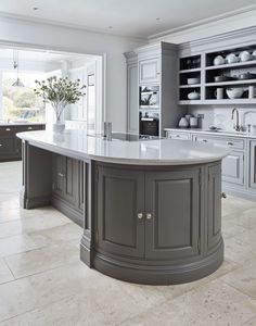 a large kitchen with an island in the middle of it and lots of cupboards