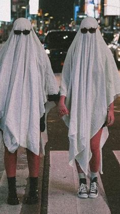 two people in white capes walking down the street