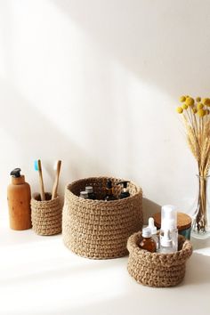 three woven baskets sitting on top of a white table