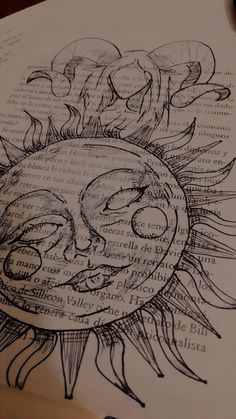 an open book with a drawing of a sun on it