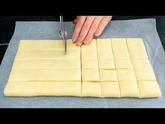 a person cutting up some food on top of a sheet of wax paper with a knife