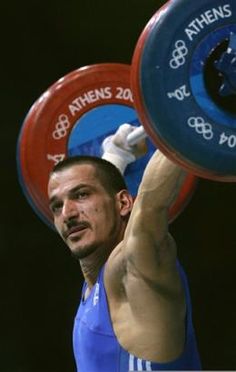 a man is lifting two heavy barbells on his shoulders