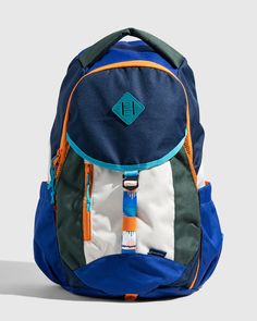 a blue and green backpack sitting on top of a white floor