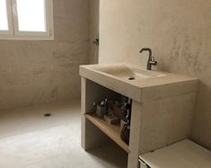 a bathroom with a sink and toilet next to a window in the wall above it