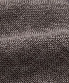 a close up view of the texture of a gray fabric with small circles on it