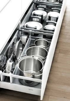 an open drawer with pots and pans in it