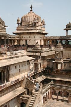 people are sitting on the roof of an old building with many pillars and domes in india