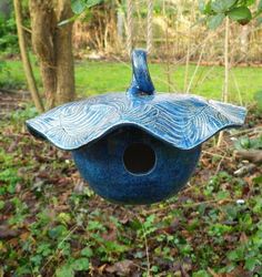 a blue bird house hanging from a tree