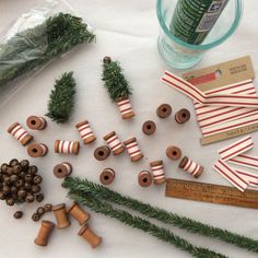 various crafting supplies laid out on top of a white table with measuring tape and pine cones