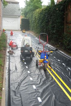 two children's toys are sitting on the tarp in front of a house