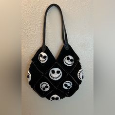 a handbag hanging on the wall with jack and sally faces painted on it's side