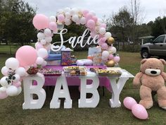 a teddy bear sitting next to a baby shower table