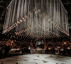 a large chandelier hanging from the ceiling at a wedding reception in an outdoor venue