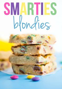 a stack of smarties blondies on top of a blue plate with candy and sprinkles