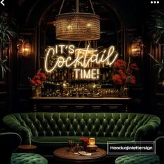 a green couch sitting in front of a bar with neon signs on the wall above it