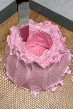 a cake with pink frosting on top and the words learn how to make pavlova