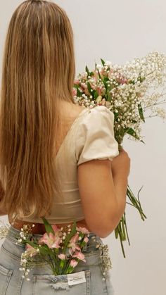 a woman holding flowers in her back pocket