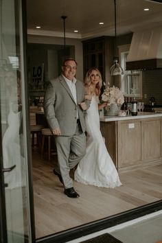 the bride and groom are walking through the kitchen