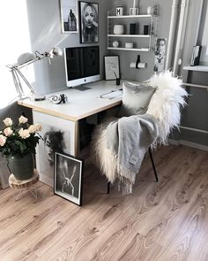 a desk with a chair and pictures on the wall