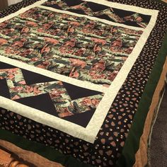 a bed with a black and white quilt on it