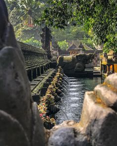 the water is running through the stone walls and into the river bed, with statues on either side