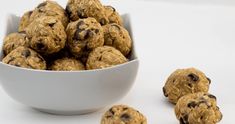 a white bowl filled with oatmeal raisin chocolate chip energy bites next to it