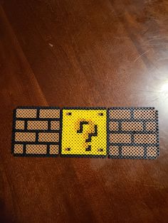 a computer keyboard made out of perforated metal parts on a wooden table top