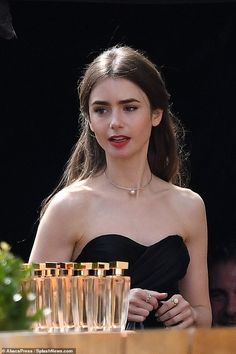 a woman in a black dress standing next to some glasses