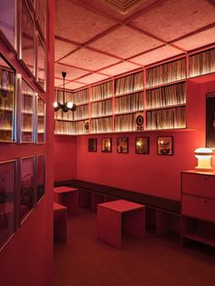 an empty room with red walls and lots of books on the shelves in front of it