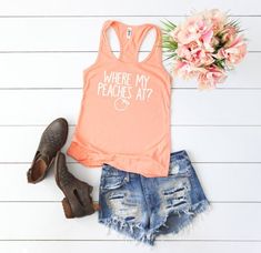 an orange tank top with the words hello kitty on it next to shorts and flowers