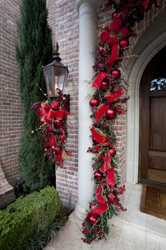 a red christmas garland hanging on the side of a building