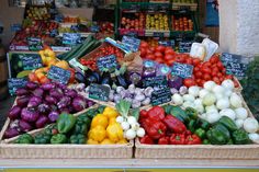 an open air market with lots of fresh fruits and vegetables in baskets on display for sale