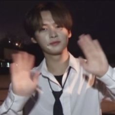 a young man in a white shirt and tie making the v sign with his hands