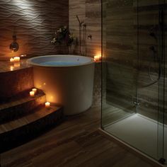 a bathroom with candles on the floor and a bathtub in the middle of it