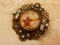 This large brooch is a lovely gift idea for hunters. The jewelry is made of bronze-colored metal and is made using the so-called layering technique, in which several ornaments are attached on top of each other. In the middle there is a simple jewelry setting with a hand-crafted glass cabochon showing a deer motif. Two acorn charms made of silver-colored metal are attached to the side. The brooch is also decorated with white half pearls and high-quality rhinestones in brown. The brooch measures 5 Animals Christmas, Wood Animal, Bronze Jewelry, A Deer, Christmas Jewelry, Simple Jewelry, Glass Crafts, Bronze Color, Lovely Gift