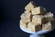 a white plate topped with cubes of food on top of a black tablecloth