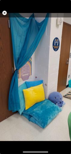 a bed with blue drapes and yellow pillows