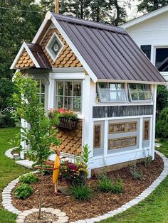 a small white house with a brown roof