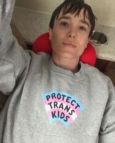 a young boy wearing a sweatshirt that says protect transs kids