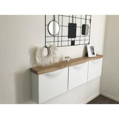 there is a white cabinet with two mirrors on it and a mirror hanging above it