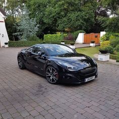 a black sports car parked in front of a house