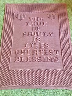 a pink crocheted blanket with the words, god and family is in it