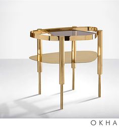 an oval table with two legs and a glass top on the bottom is shown in gold