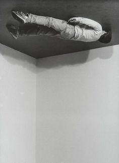 a black and white photo of a person laying on the ceiling