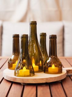 several brown bottles with candles in them on a wooden table