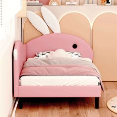 a pink bed with two white surfboards on the headboard and bottom shelf above it