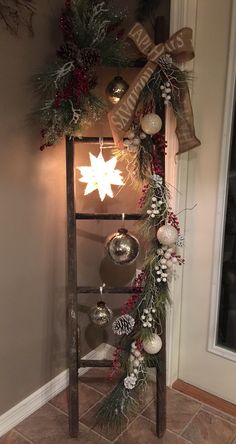 a christmas display with ornaments and lights on the side of a door, in front of a window